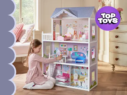 A child playing with the Sadie's Wooden Doll House in a bedroom