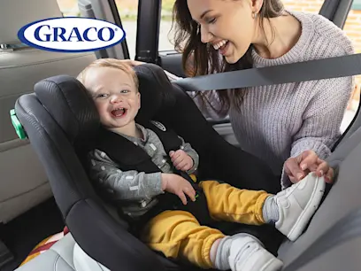 Child laughing and sitting in a black car seat