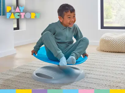 A kid playing on the Play Factory Sensory Spinning Chair blue in a bright room.