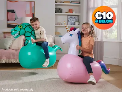 Two children ride inflatable hopper toys indoors, one shaped like a green dinosaur and the other a pink unicorn. A badge highlights prices of €10 and below, with a note that products are sold separately.
