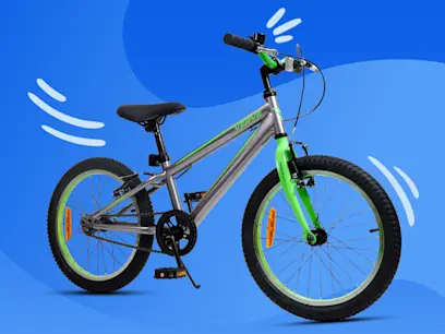 Silver and green children's bicycle shown against a blue graphic background with decorative motion lines. Features knobby tires, front and rear brakes, reflectors, and a kickstand, displayed in a three-quarter side view.
