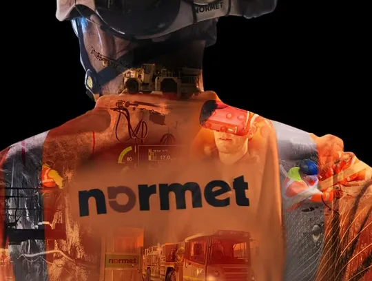 Man wearing a normet jacket. In the jacket are transparent overlays of normet's mining equipment