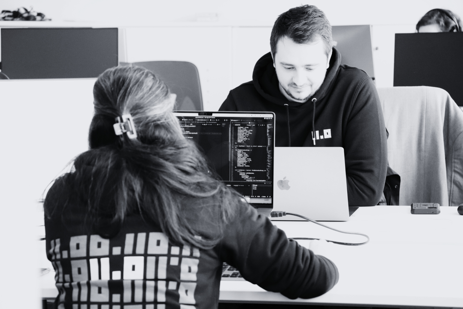 Two developers of the Two Point O team working on our clients' platforms and wearing our Two Point O sweatshirts