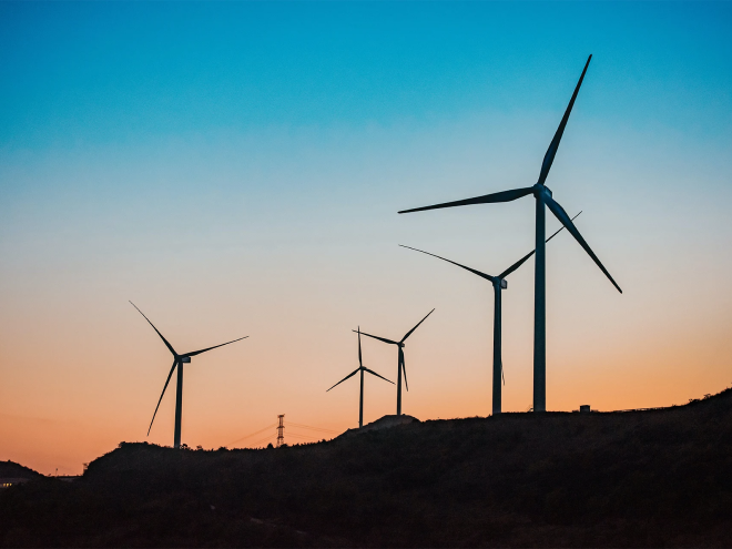 Background image for our Degroof Petercam case showing windmills at sunrise