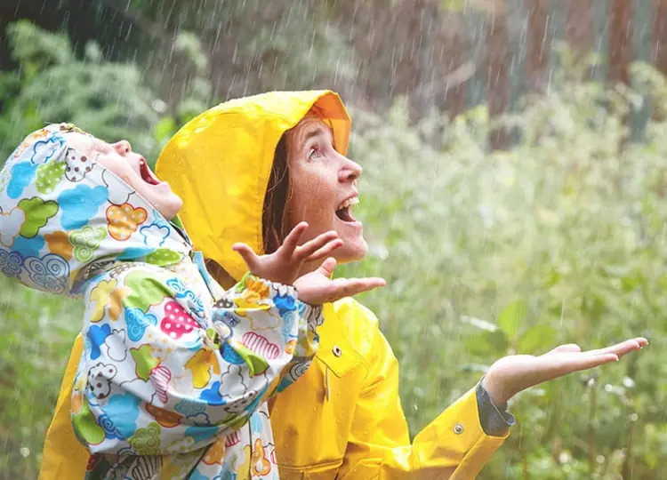 Mujer y niño con inmunidad fuerte disfrutando de la lluvia