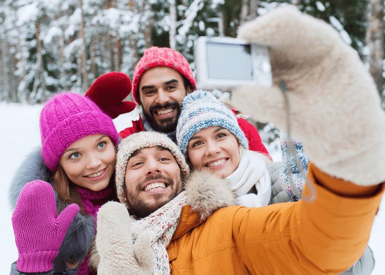 Grupo de amigos tomándose selfie en paisaje de nieve