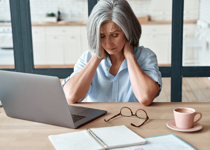 Mujer mayor de 50 años sintiéndose con menos energía durante el trabajo 