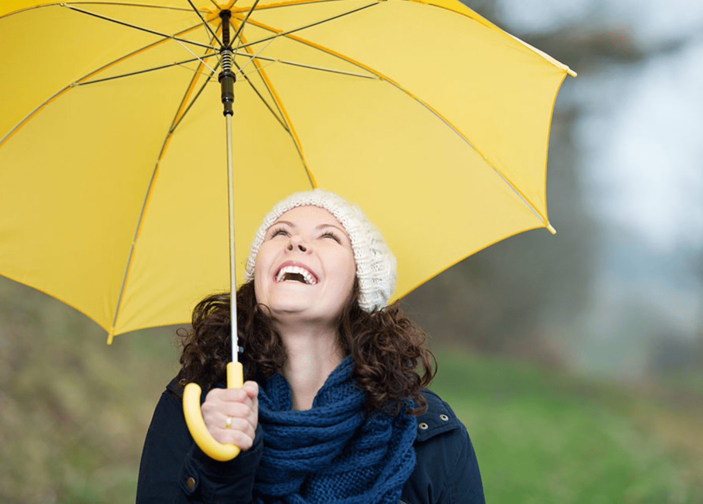 Chica con sombrilla amarilla y un sistema inmunológico sano disfrutando de la lluvia 