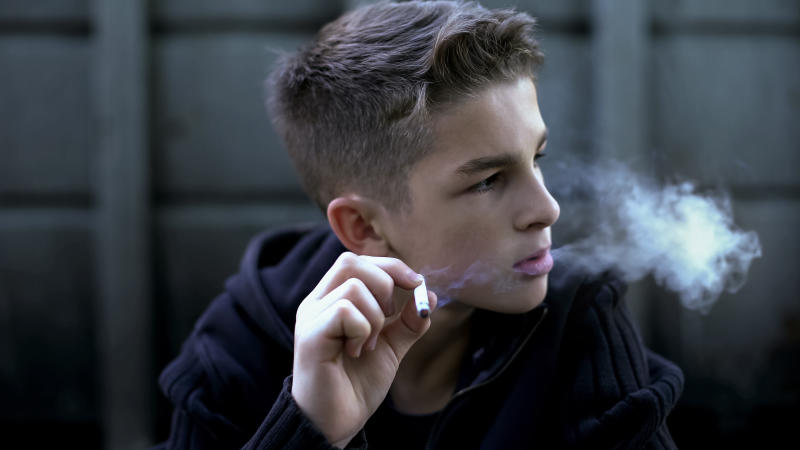 Young man smokes cigarette