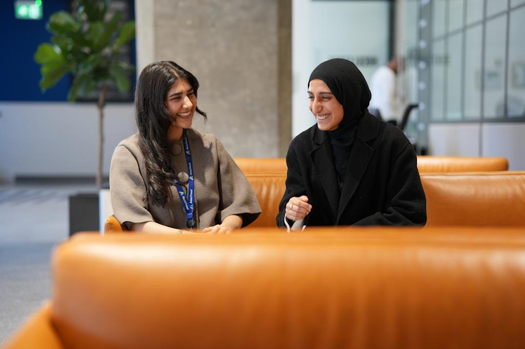 Two Anna Freud interns seated, smiling and laughing.