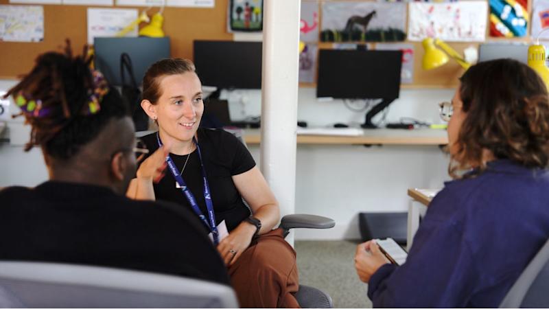 Three Anna Freud staff in conversation in office.