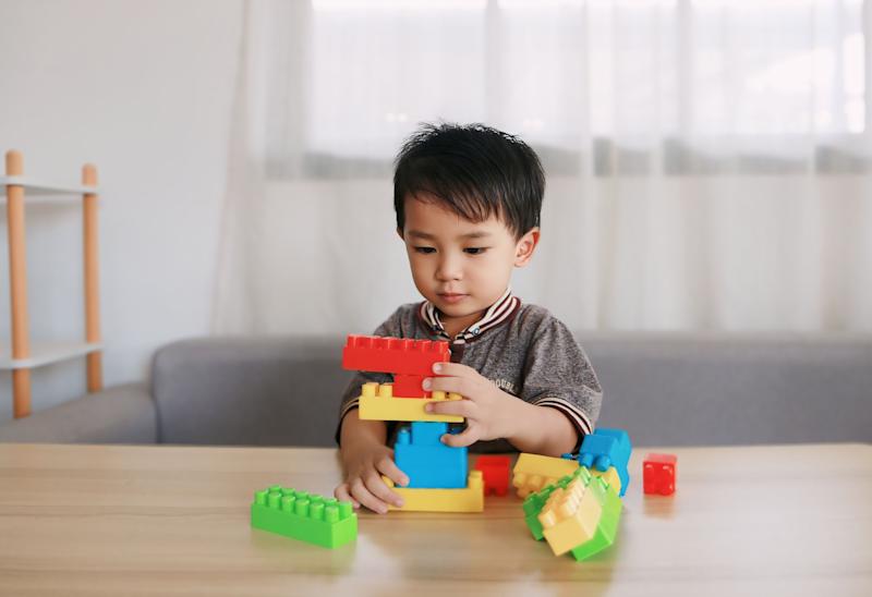 Young boy sitting at a table playing with Lego.