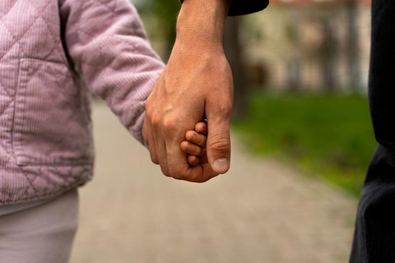 Parent/adult holding a child's hand.