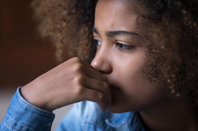 Close-up of a young girl facing away from the window.
