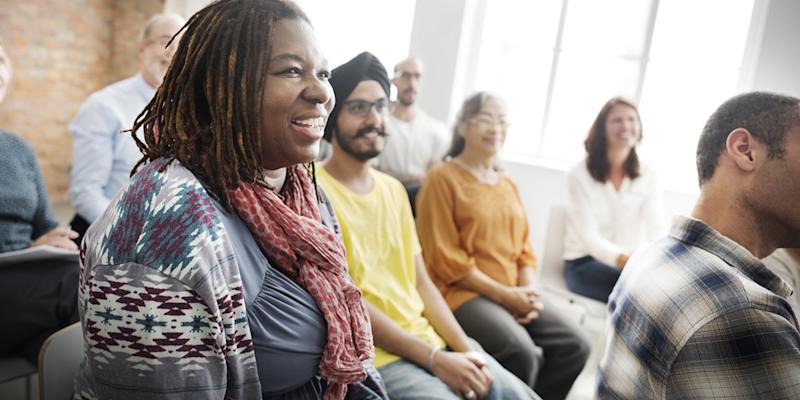 Individuals in a group training, smiling and looking engaged.