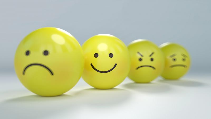 Four yellow balls placed in a line, with sad, happy, angry and concerned expressions.