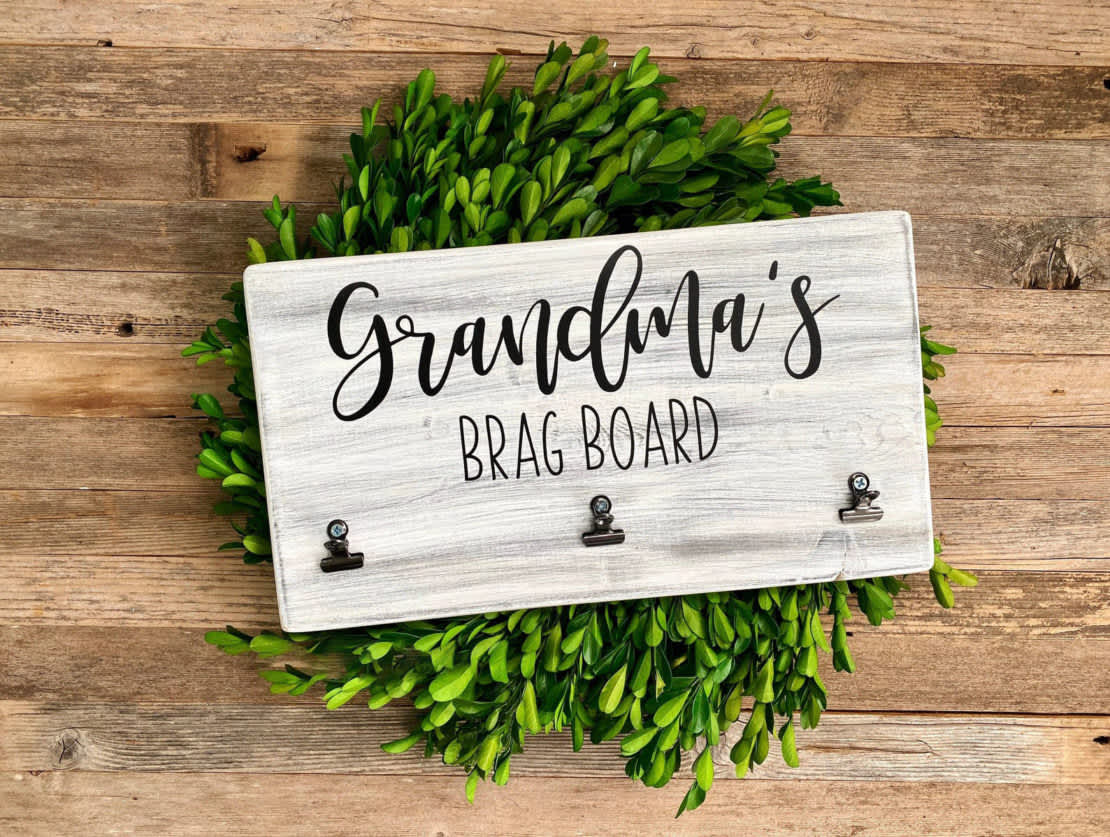 Gray wooden grandma brag board on top of a green wreath