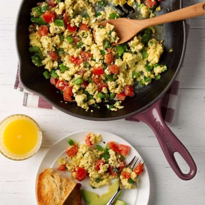 Vegetable scrambled eggs with a glass of orange juice