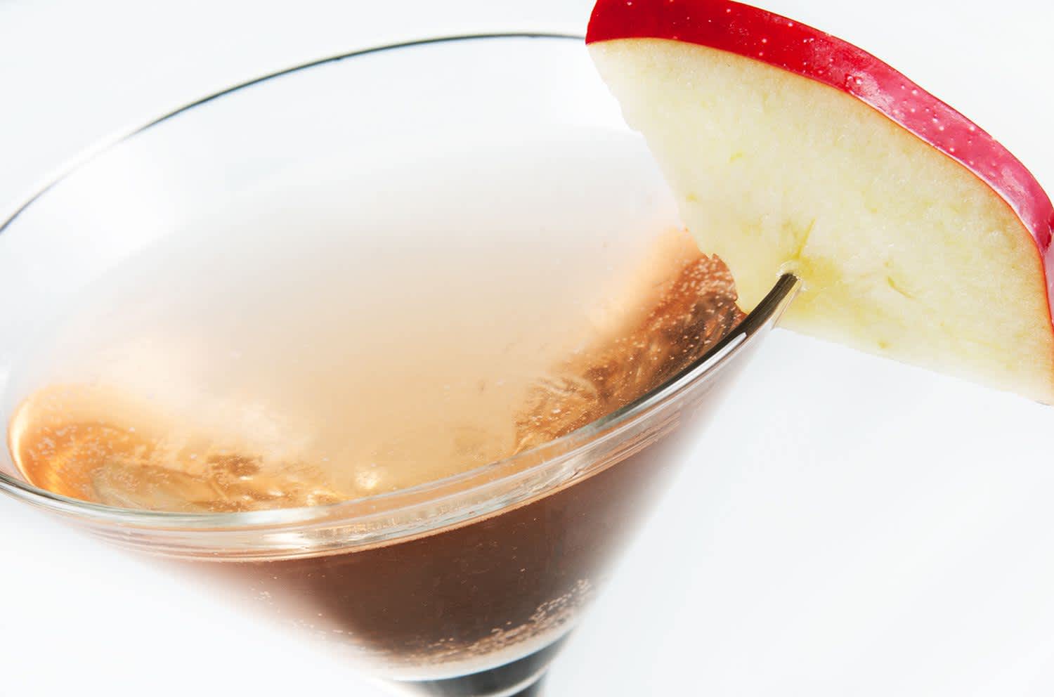 Appletini mocktail in martini glass with apple wedge garnish 