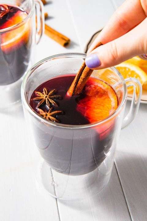 A glass of mulled wine with cinnamon, orange and star anise garnish