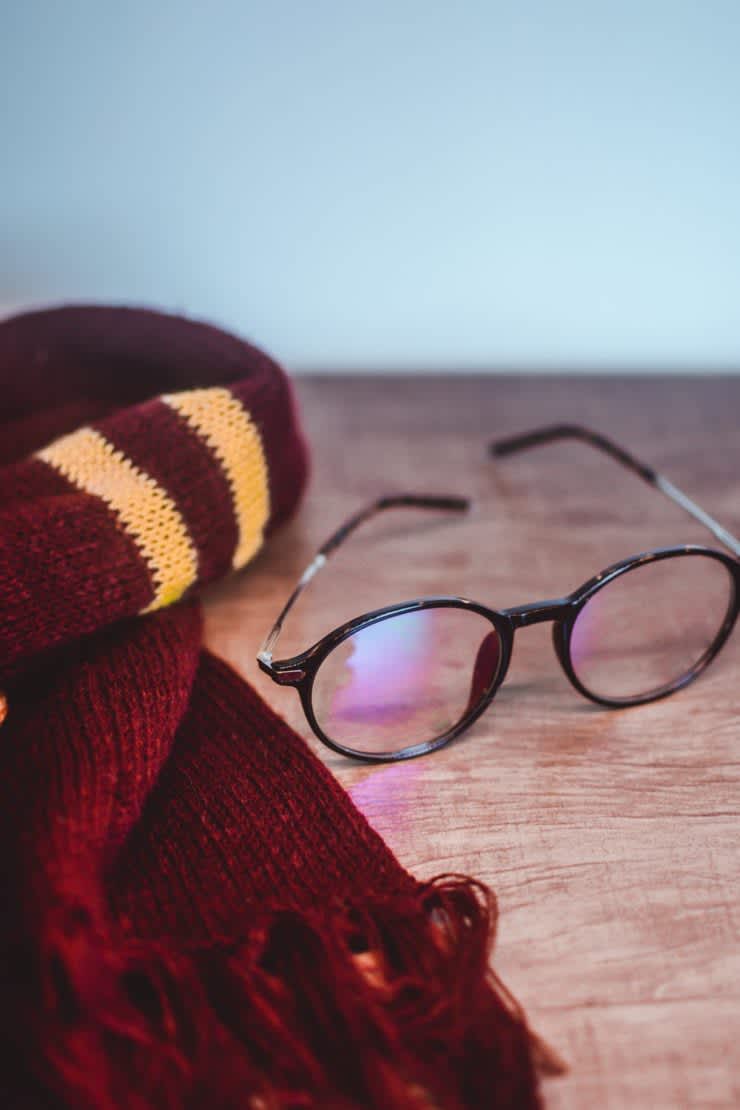 Harry Potter-themed Maroon & gold striped scarf with glasses on table