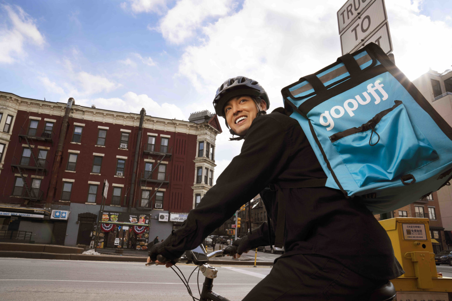 A man riding a bike with Gopuff backpack on, delivering orders