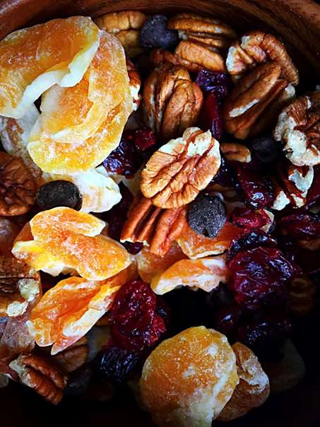 A close-up of a snack mix with dried fruit and nuts