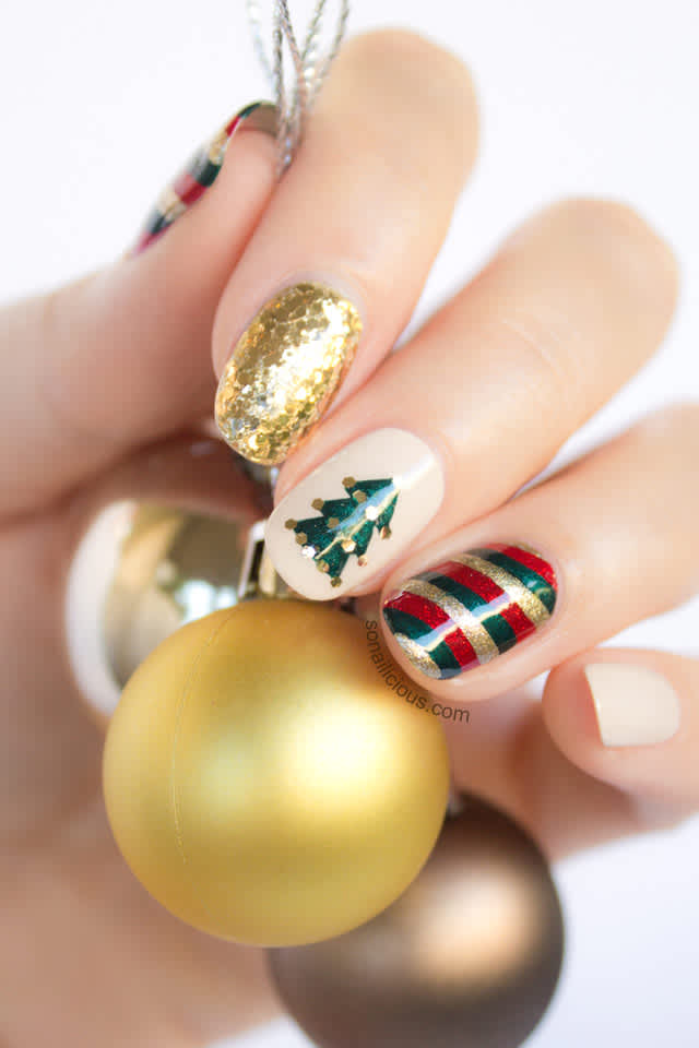 Nails with assorted Christmas nail art, including Christmas tree, gold glitter & red, green & gold stripes