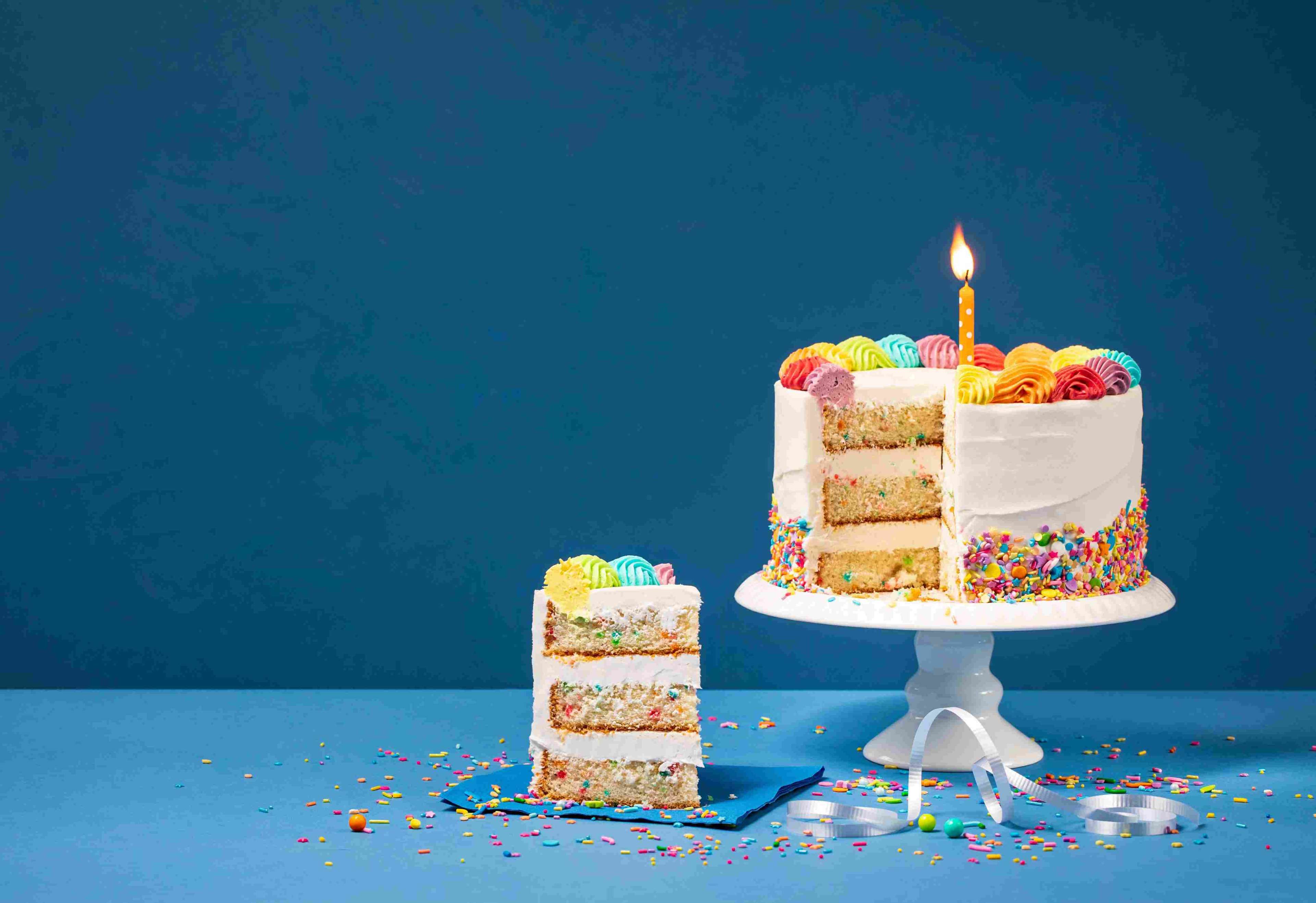 61a1420cc3249d0b0c557585_Colorful%20Birthday%20Cake%20with%20Slice%20and%20Sprinkles%20on%20Blue%20background.jpeg