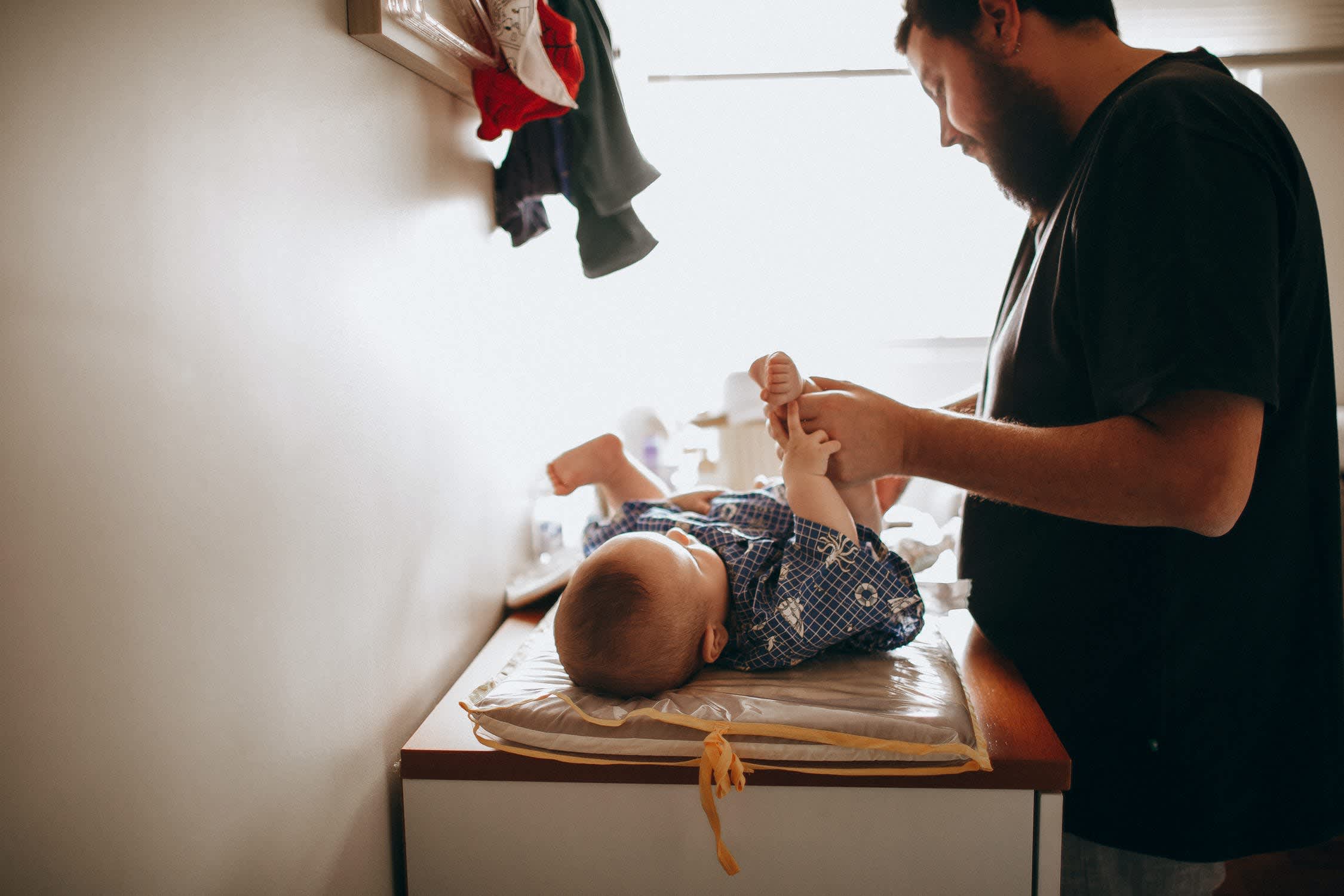 Father changing a baby's diaper on a table