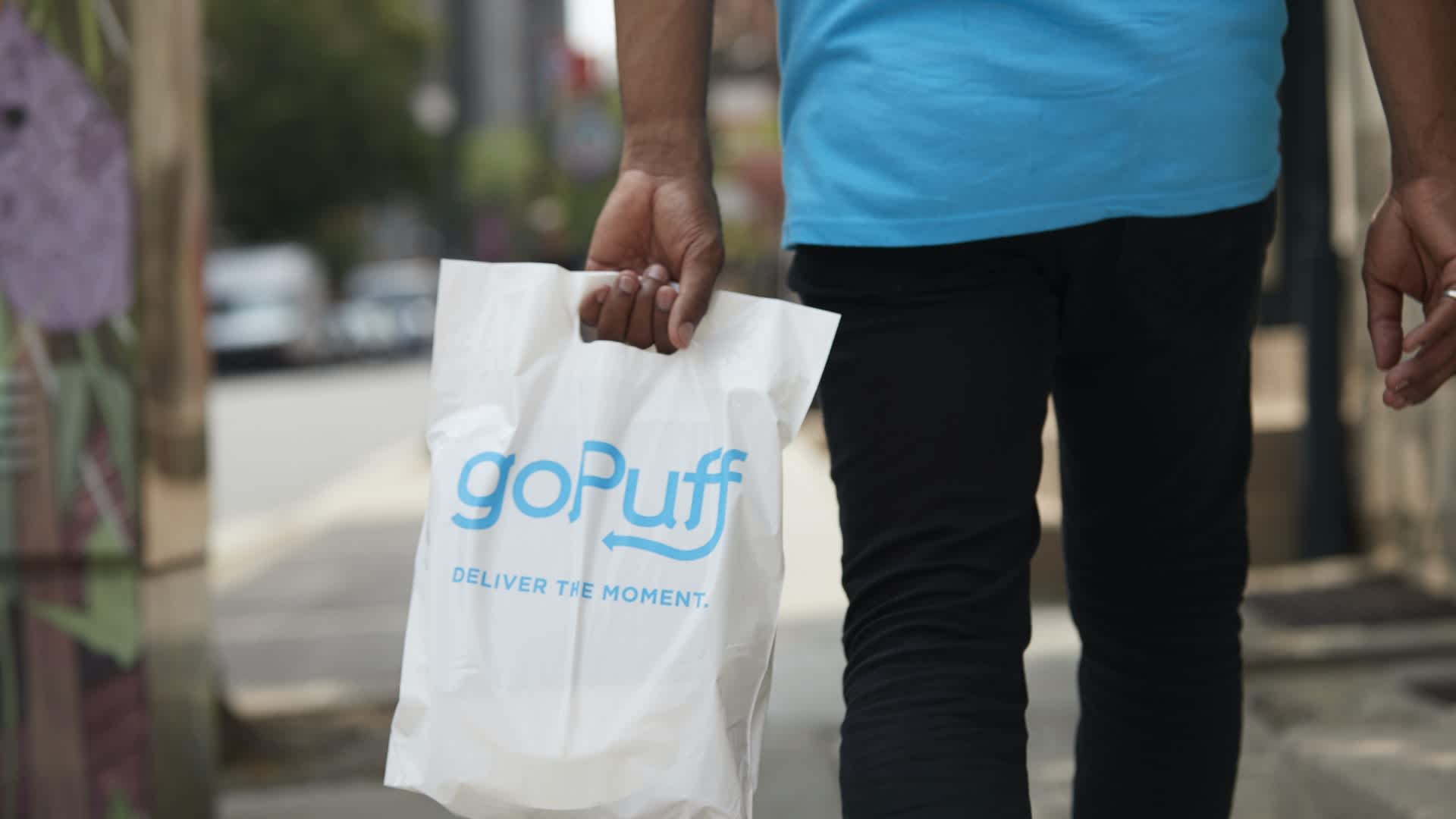 man carrying bag labeled "Gopuff: Deliver the Moment"