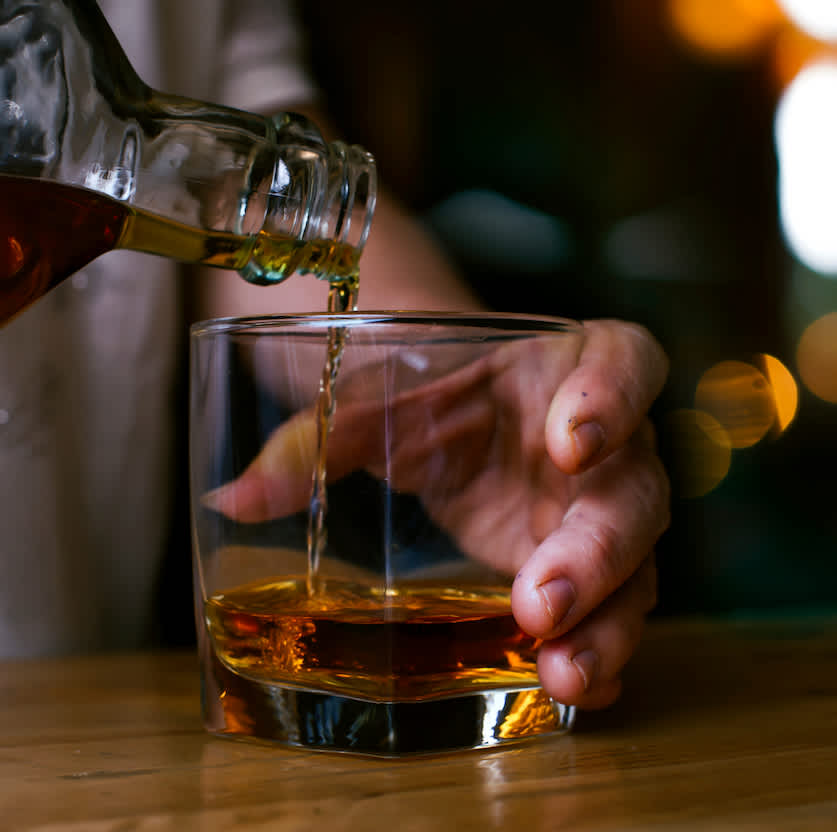 Bartender pouring whiskey into a glass