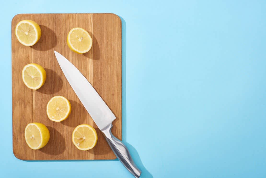 Yellow cut lemons on wooden board