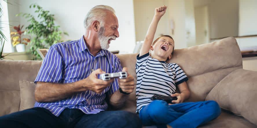Man and boy on the couch playing console games