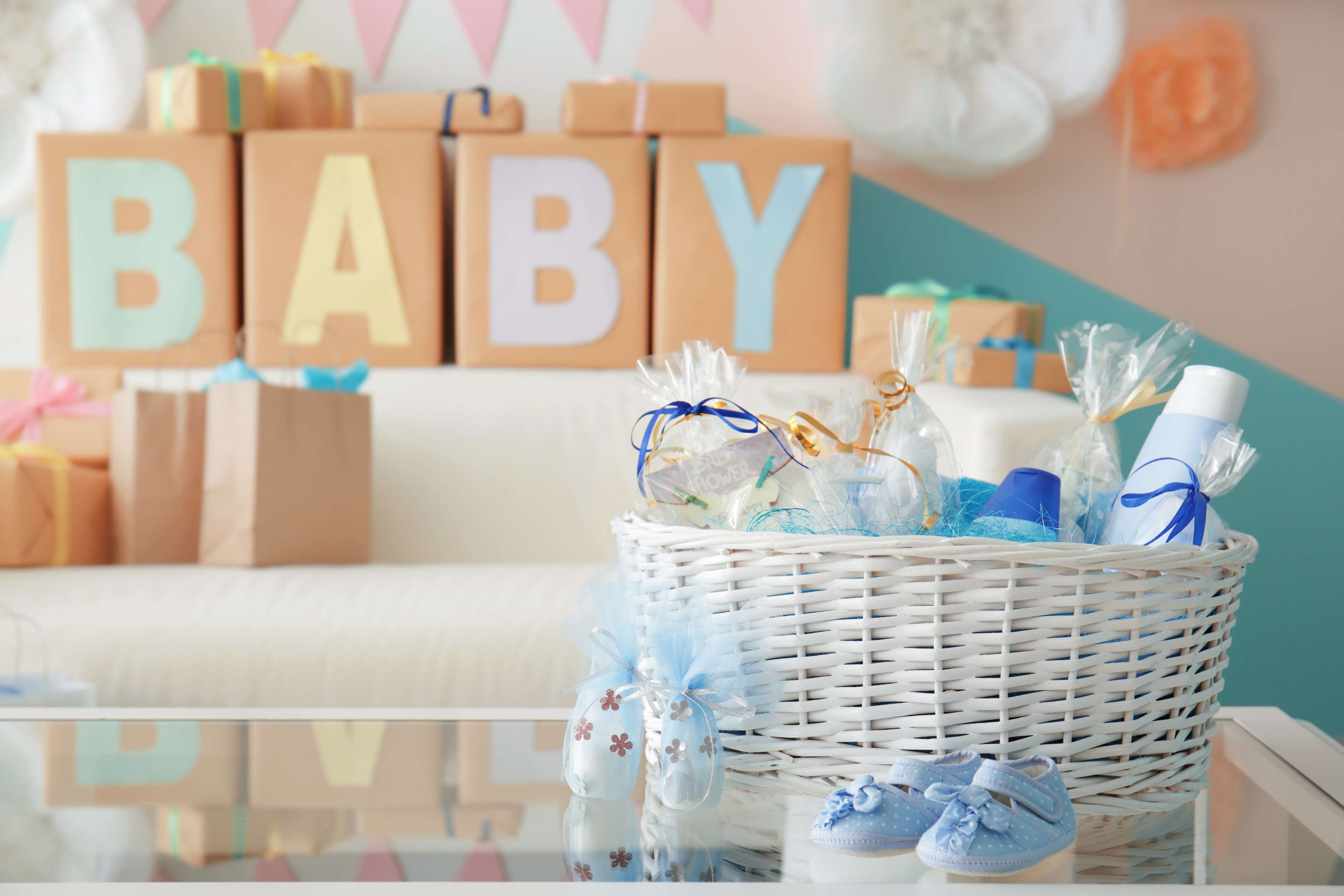62017bdaf670eafa739b0f0c_Wicker%20basket%20with%20gifts%20for%20baby%20shower%20party%20on%20table%20indoors.jpeg