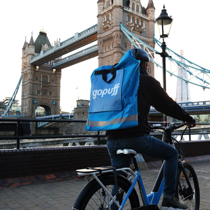 Man riding a bike with Gopuff backpack on near London Bridge