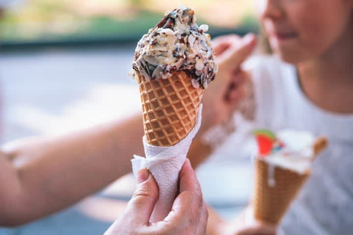 A hand holding an ice cream cone