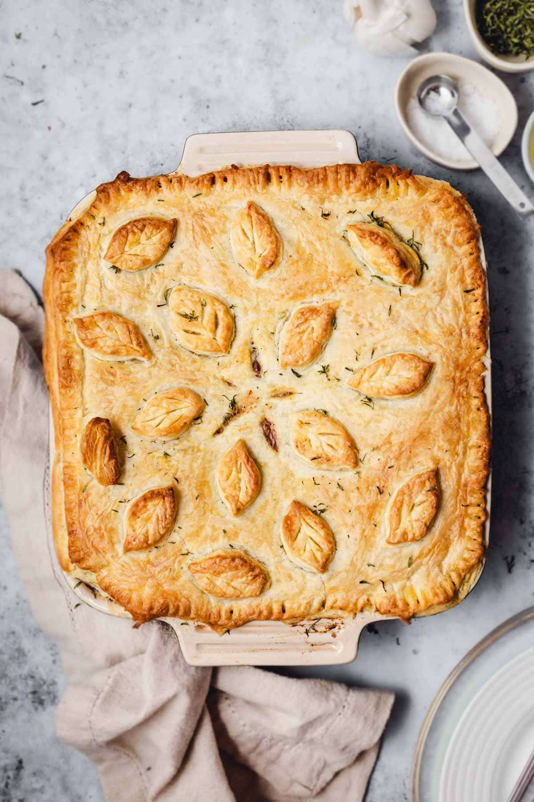 Vegan pot pie with flaky pastry crust and leaves designed on the crust.