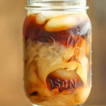 Ball mason jar filled with creamy iced coffee drink 