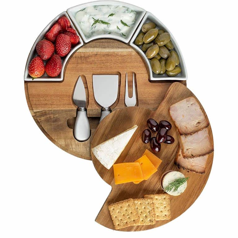 Wooden cheese board with charcuterie and cheese knives
