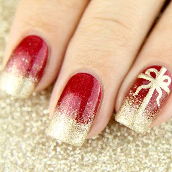 red nails with speckled gold tips & accent nail with golden present bow 