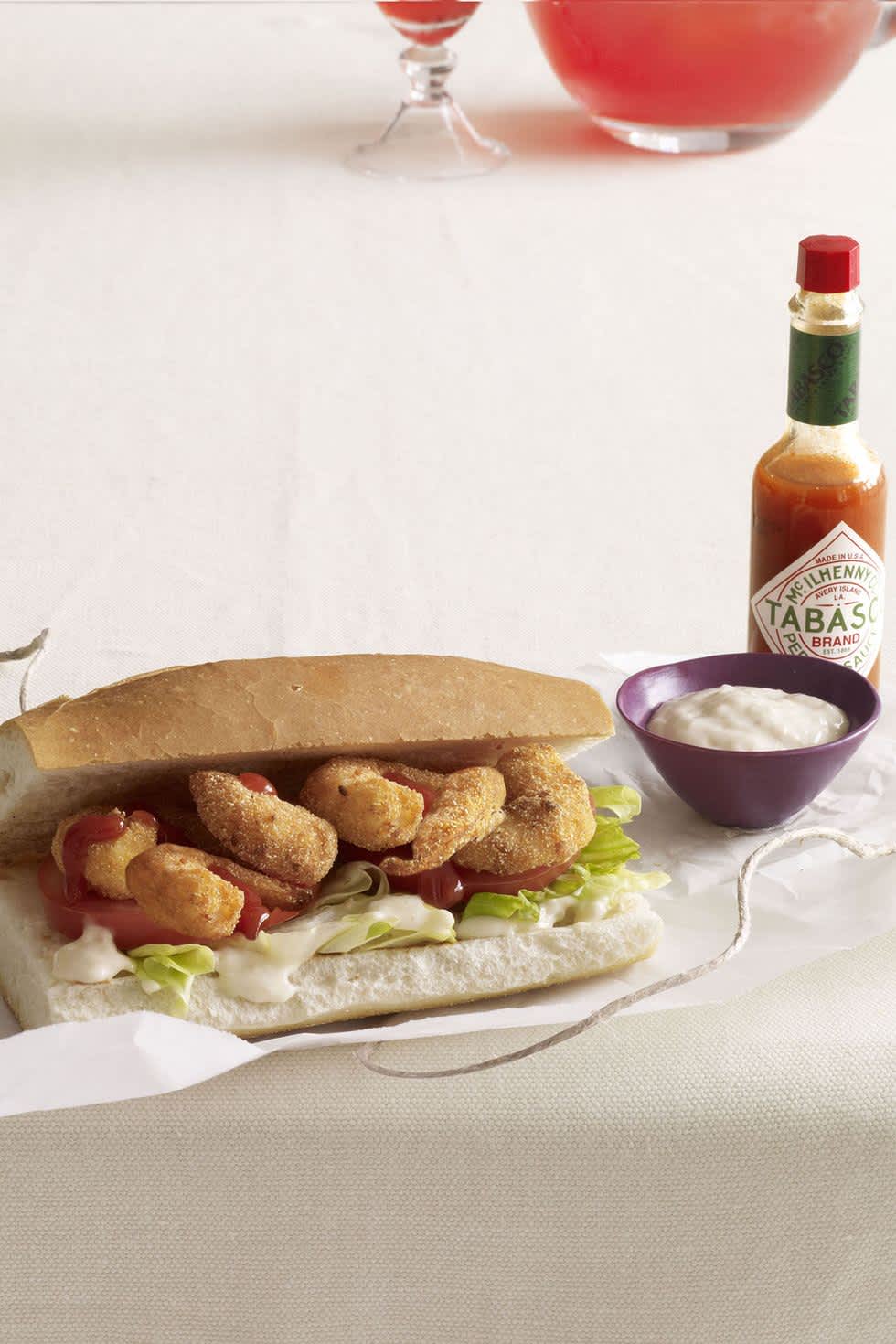 Fried shrimp po’boy served with a side of tartar sauce and hot sauce