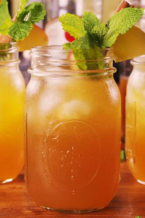 An apple cider mojito served in a mason jar with a sprig of mint