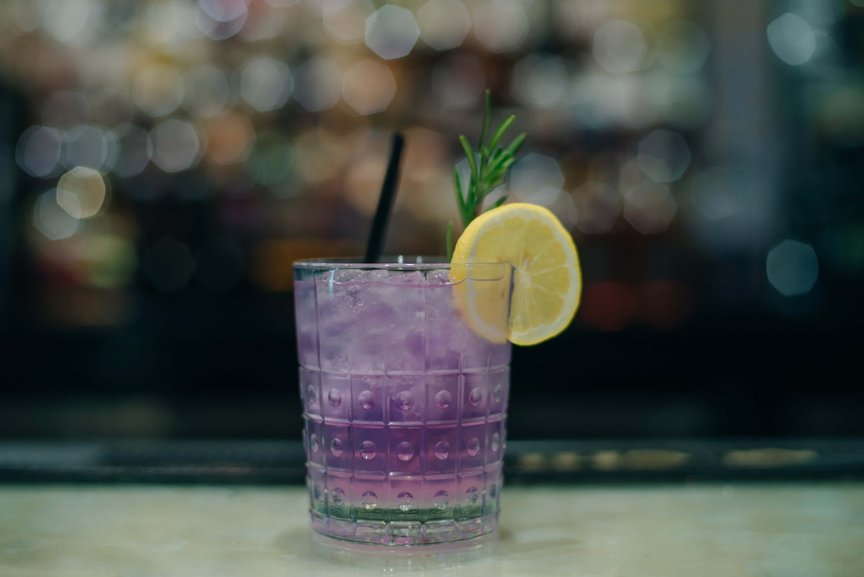 purple cocktail with lemon