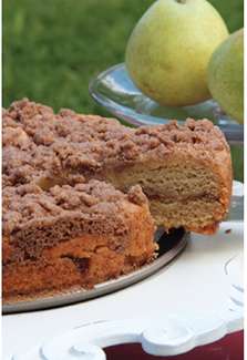 A round gluten-free coffee cake topped with apple cinnamon-sugar crumbles.
