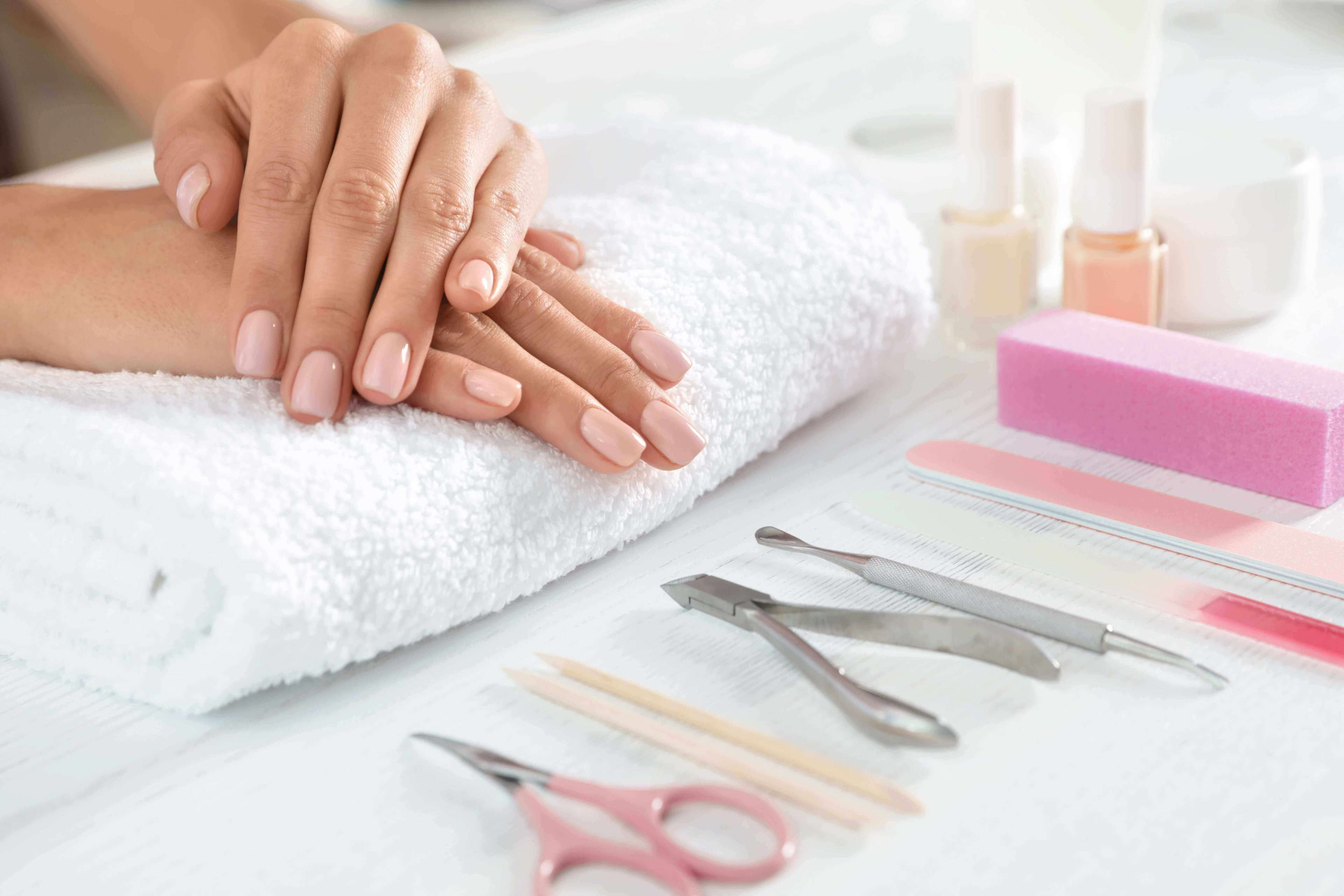 Woman waiting for manicure and tools on table, closeup with space for text