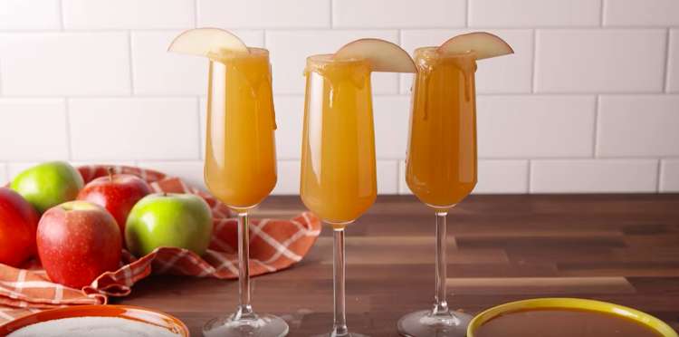 3 champagne flutes filled with caramel apple mimosas