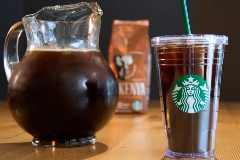 Pitcher & Starbucks cup filled with Starbucks iced coffee near bag of Kenya coffee blend