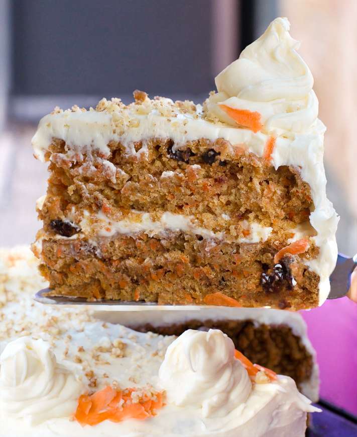 Vegan carrot cake with frosting on top and through the middle of the cake.