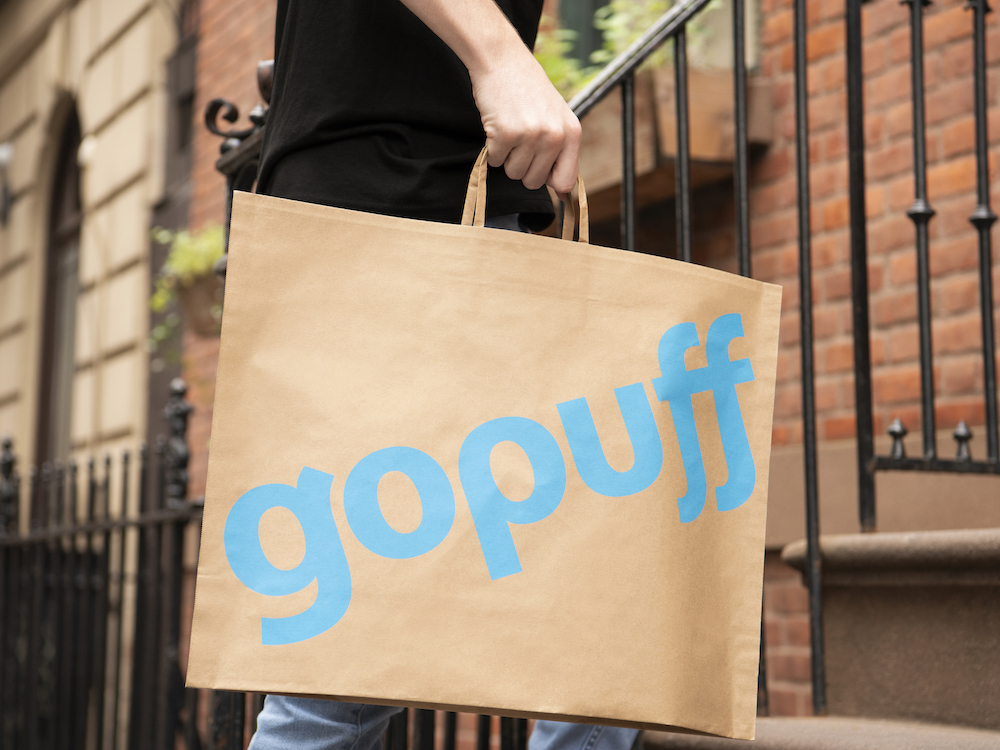 A person carrying Gopuff paper bag